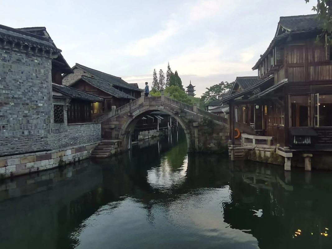Ancient stone arch bridges in Nanxun Ancient Town featuring classic Ming and Qing stone bridge architecture mirrored in winding waterways of Jiangnan water town
